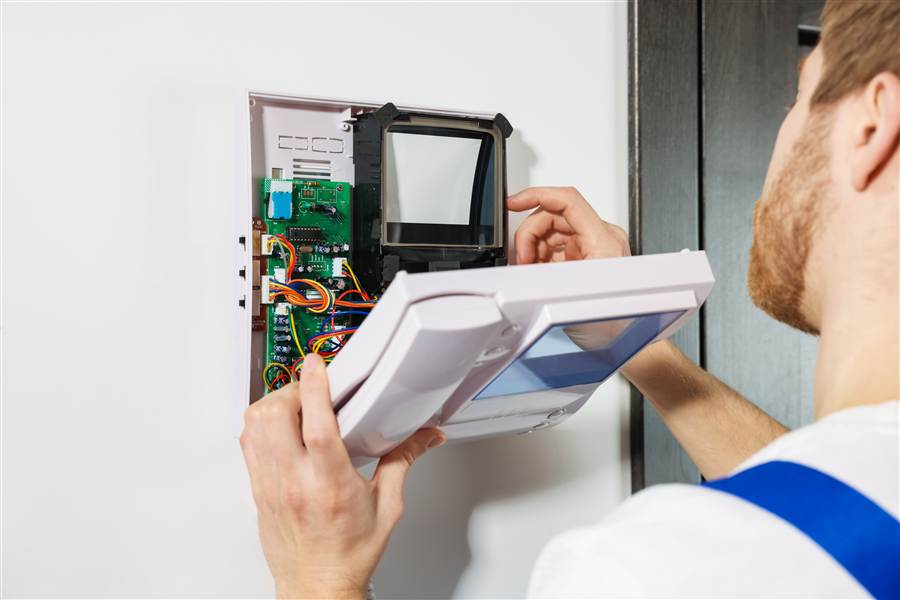 Technician servicing an open equipment panel on site