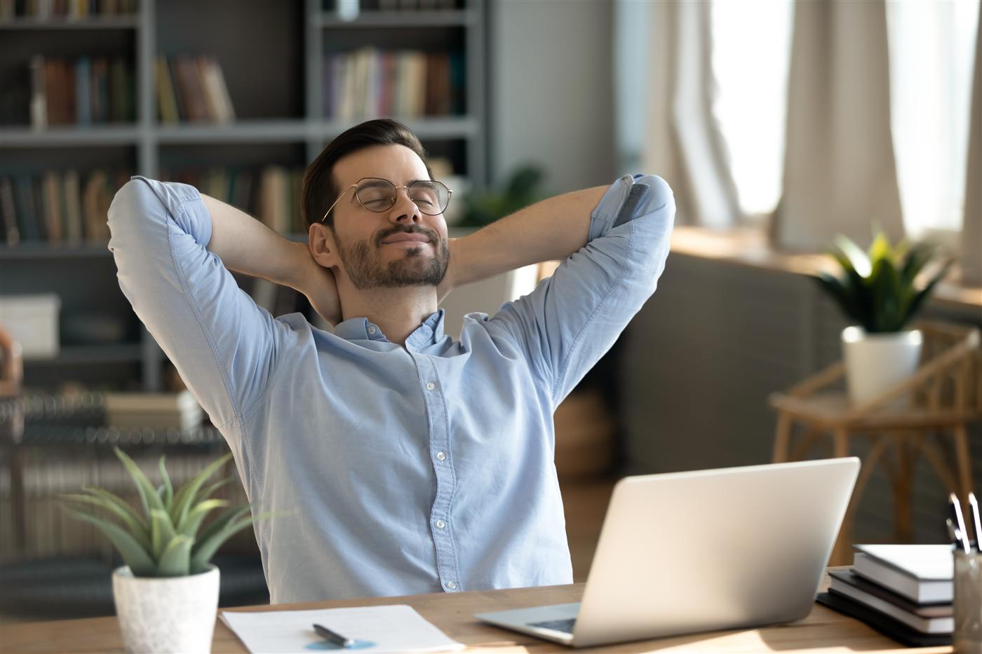 Relaxed professional leaning back at his desk, stress-free